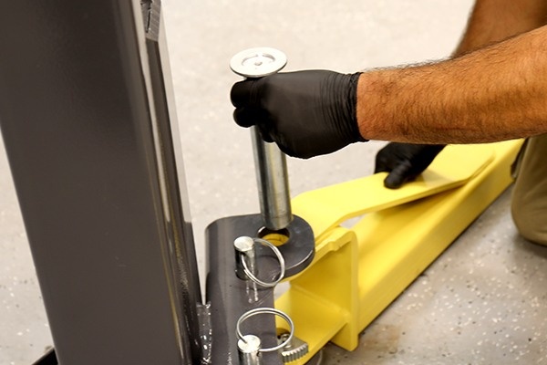 Secure MaxJax adjustable lift arms to columns using drop-in pivot pins for a stable lifting setup.